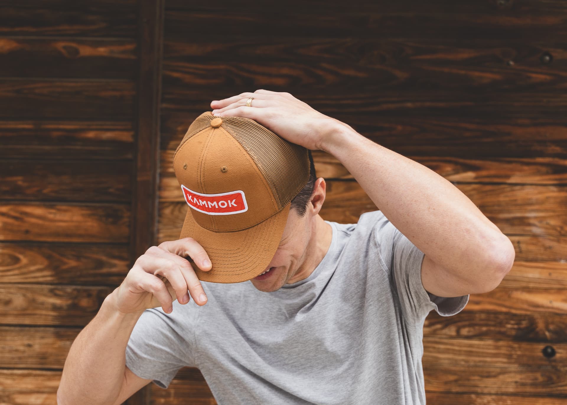 A man putting a Kammok Hat on his head.